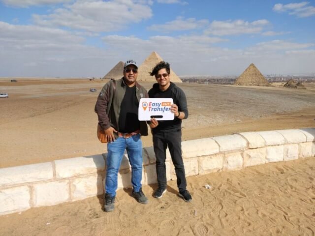 guests holding our sign in front of pyramids 4