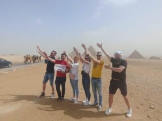 guests holding our sign and posing in front of pyramids