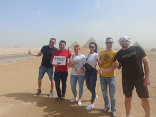 guests holding our sign in front of pyramids 1