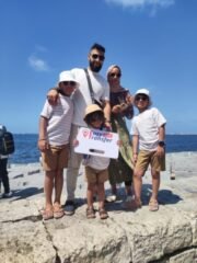 guests holding our sign in front of white sea